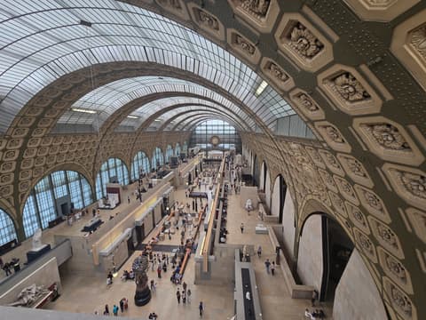 The Musee d'Orsay main hall under its curved glass roof, ultra-wide view